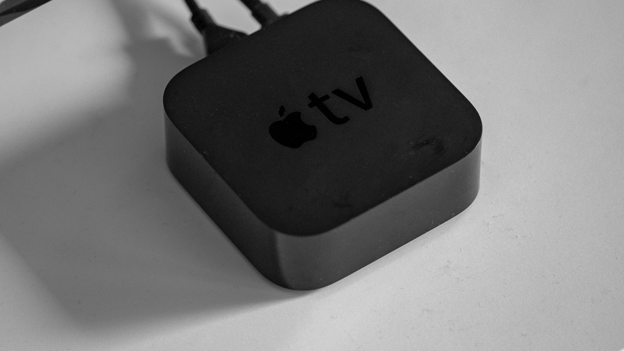 Boîtier de streaming TV noir relié en HDMI, posé sur un meuble